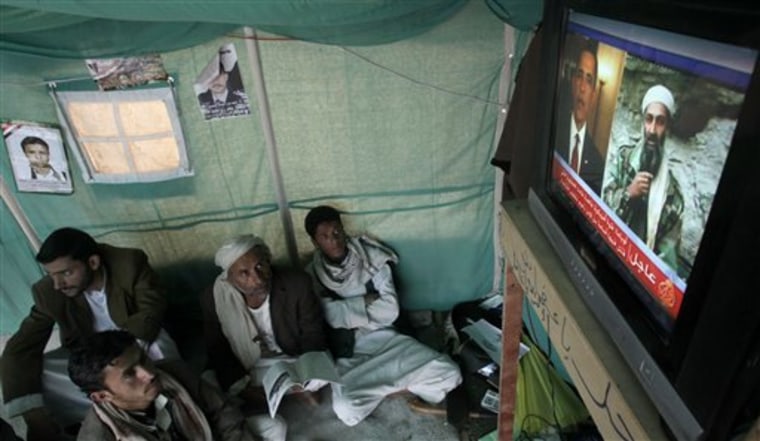 Anti-government protesters in Yemen watch a TV report about the killing of Al-Qaida leader Osama bin Laden.  